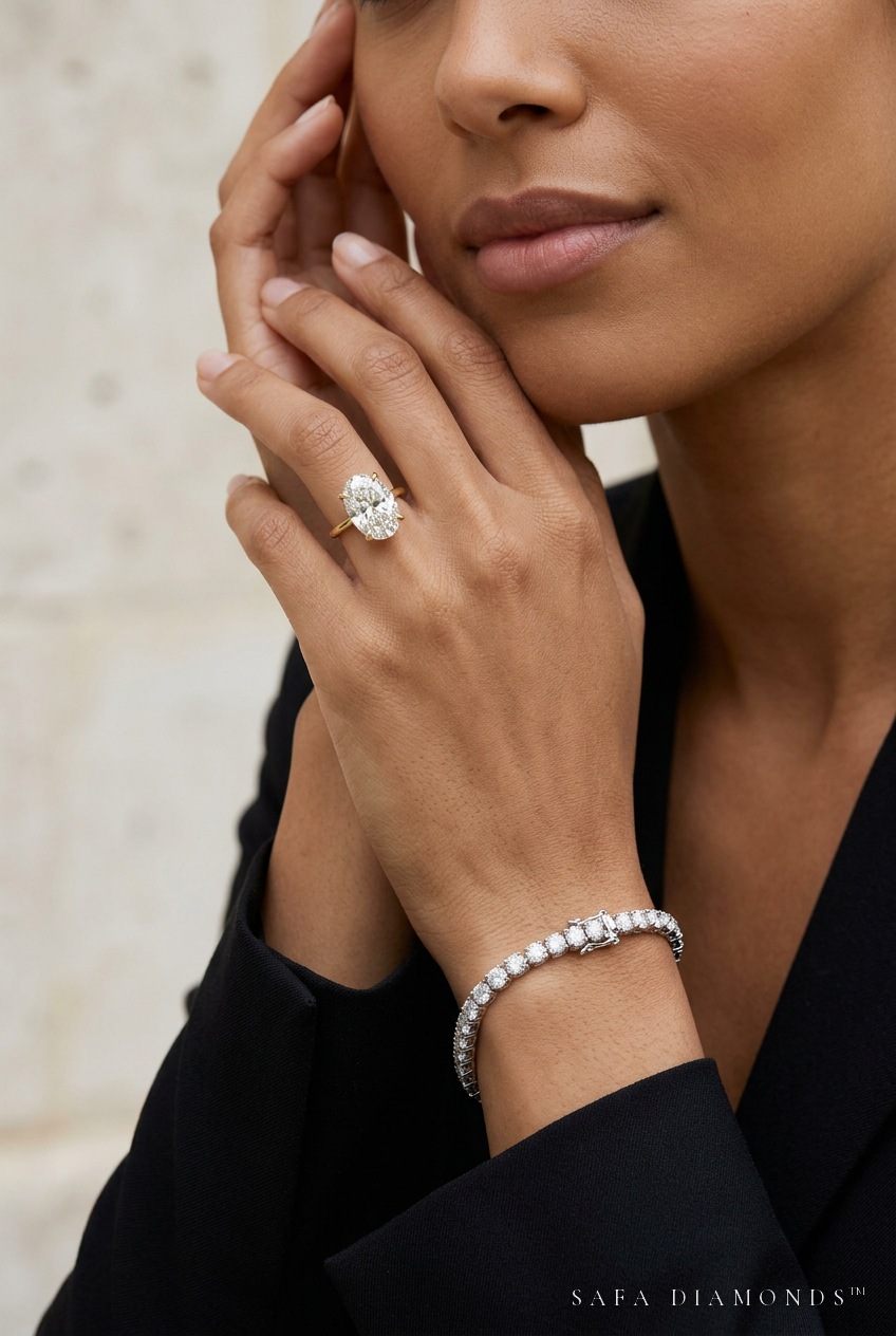 Model wearing an oval solitaire ring and diamond tennis bracelet